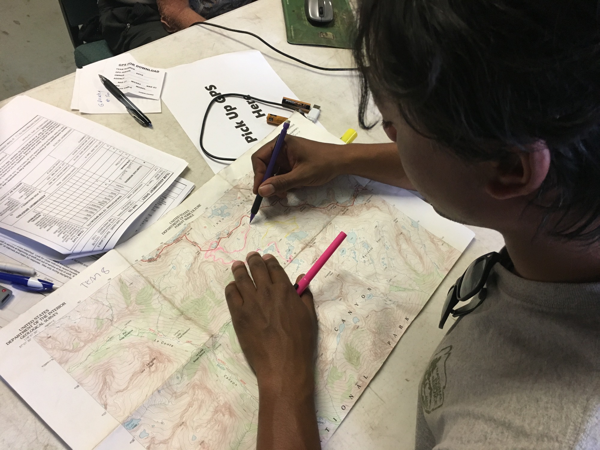 A staff member draws on a topographical map. 