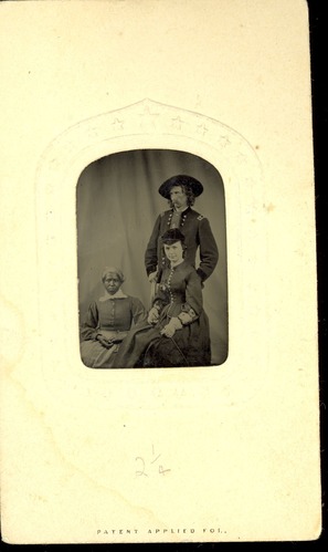 George Armstrong Custer in Military Uniform and Hat with Long Hair, standing Behind Elizabeth Bacon Custer with an African American Servant