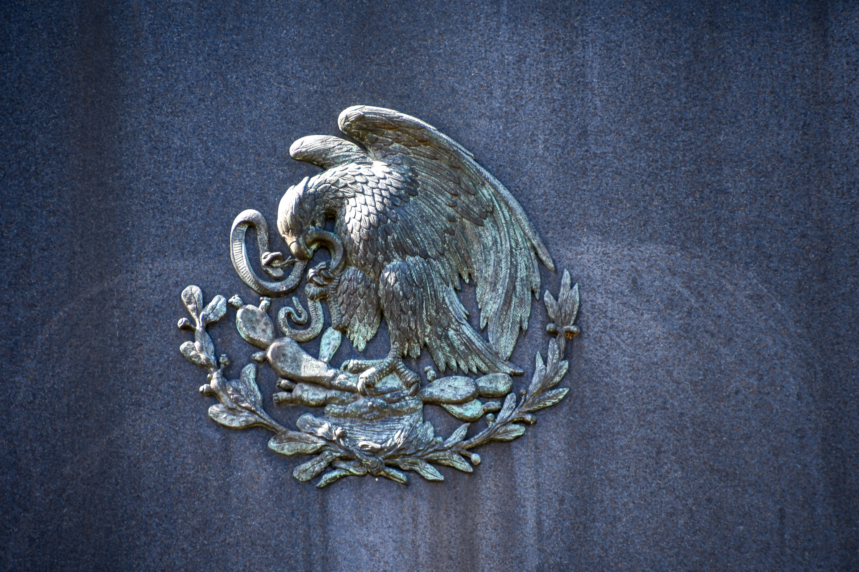 Bronze sculpture of eagle perched on a prickly pear cactus devouring a rattlesnake