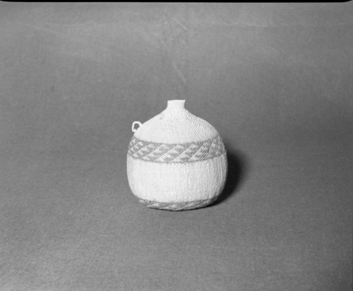 Mrs. Donald Segerstrom Collection. Object: Paiute seed jug. Dimensions: 6 3/4". Materials: all willow with design touched up with dye. Technology: three strand start, body of basket in diagonal twining, neck in plain twining, one handle in cotton string. Collection History: ---. Photographed of Michael Dixon, 1/83. Catalogued by Craig Bates and Barbara Beroza. Yosemite Collections, National Park Service.