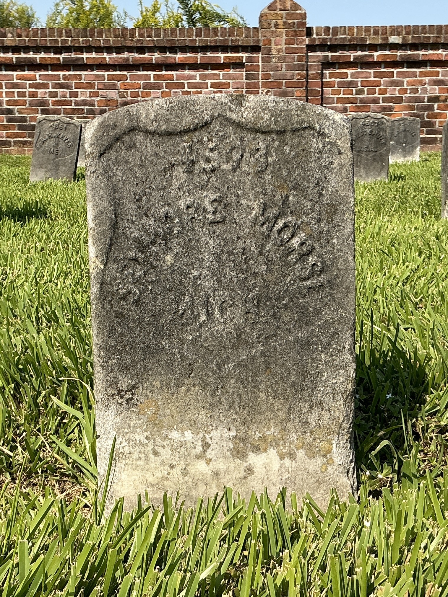Front of historic upright marble headstone with recessed shield face.