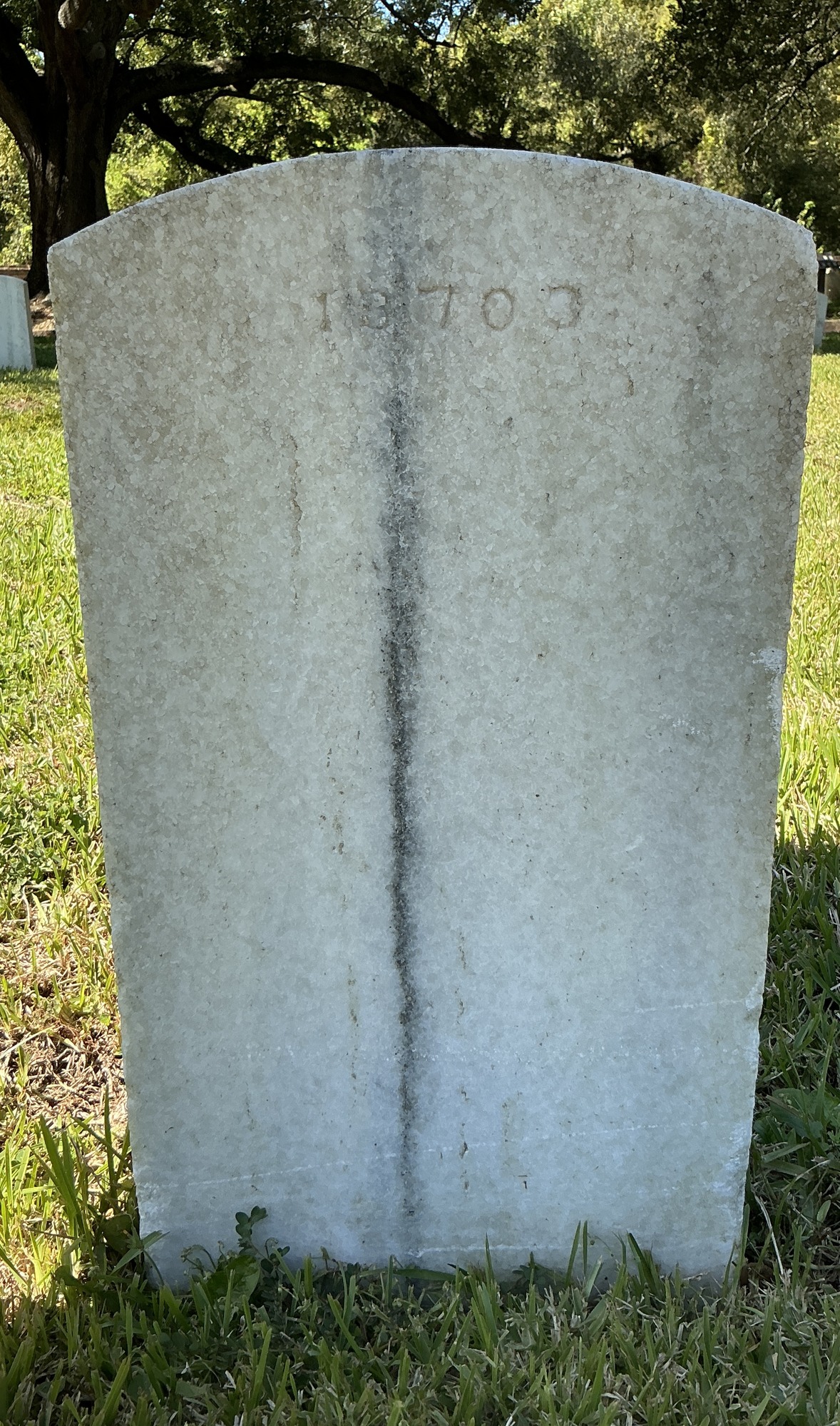 Back of upright marble headstone with flat face.