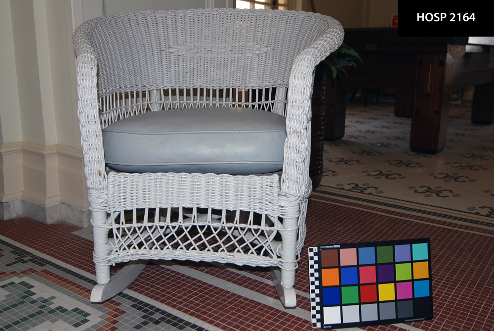 Wicker rocking chair; Repainted light gray; double-arrow pattern woven into center of back; curved semicylindrical back slopes slightly at front to form arms; openwork wicker below & above seat; X-shaped support connects legs near wooden rockers; Originally painted beige with orange cloth cushion; repainted by HFC in 1988. Cleaned, painted, reupholstered in 1988 probably by HFC; treatment reports not in file.