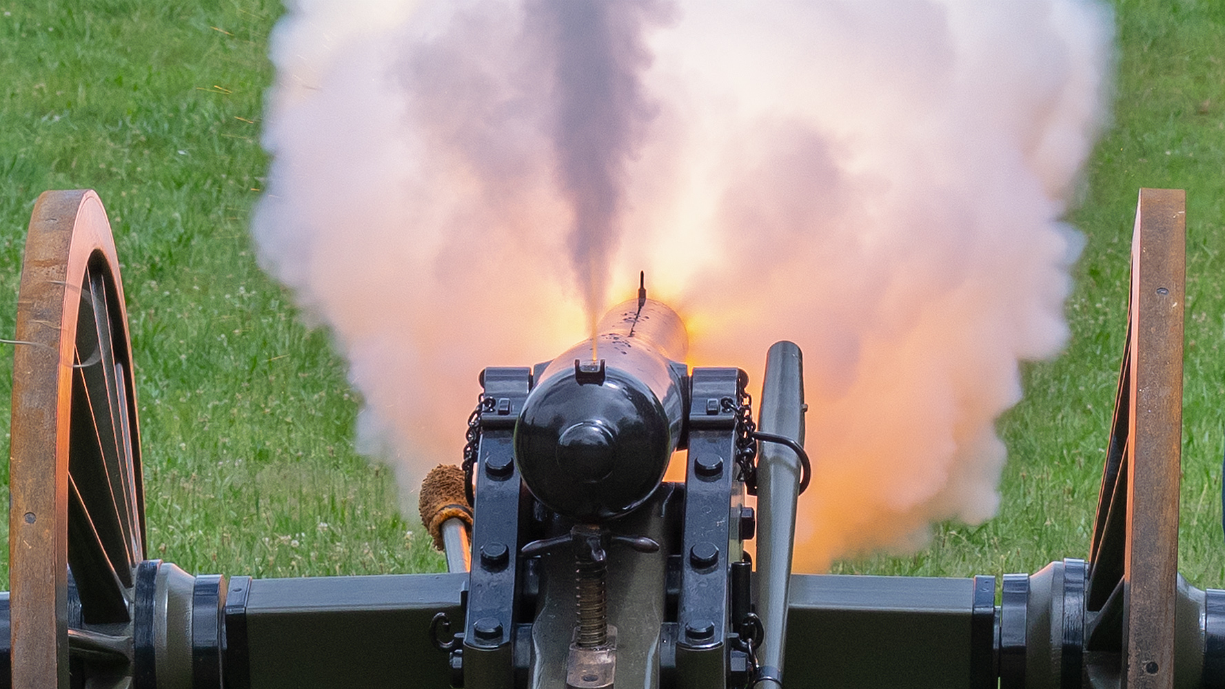 A detailed photo of a cannon at the precise moment of firing.