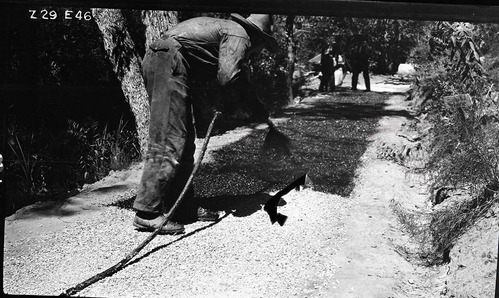 Narrows Trail construction, workmen spraying bitumuls 150 on locking course. Expensive hand methods necessary for work on the Narrows Trail.