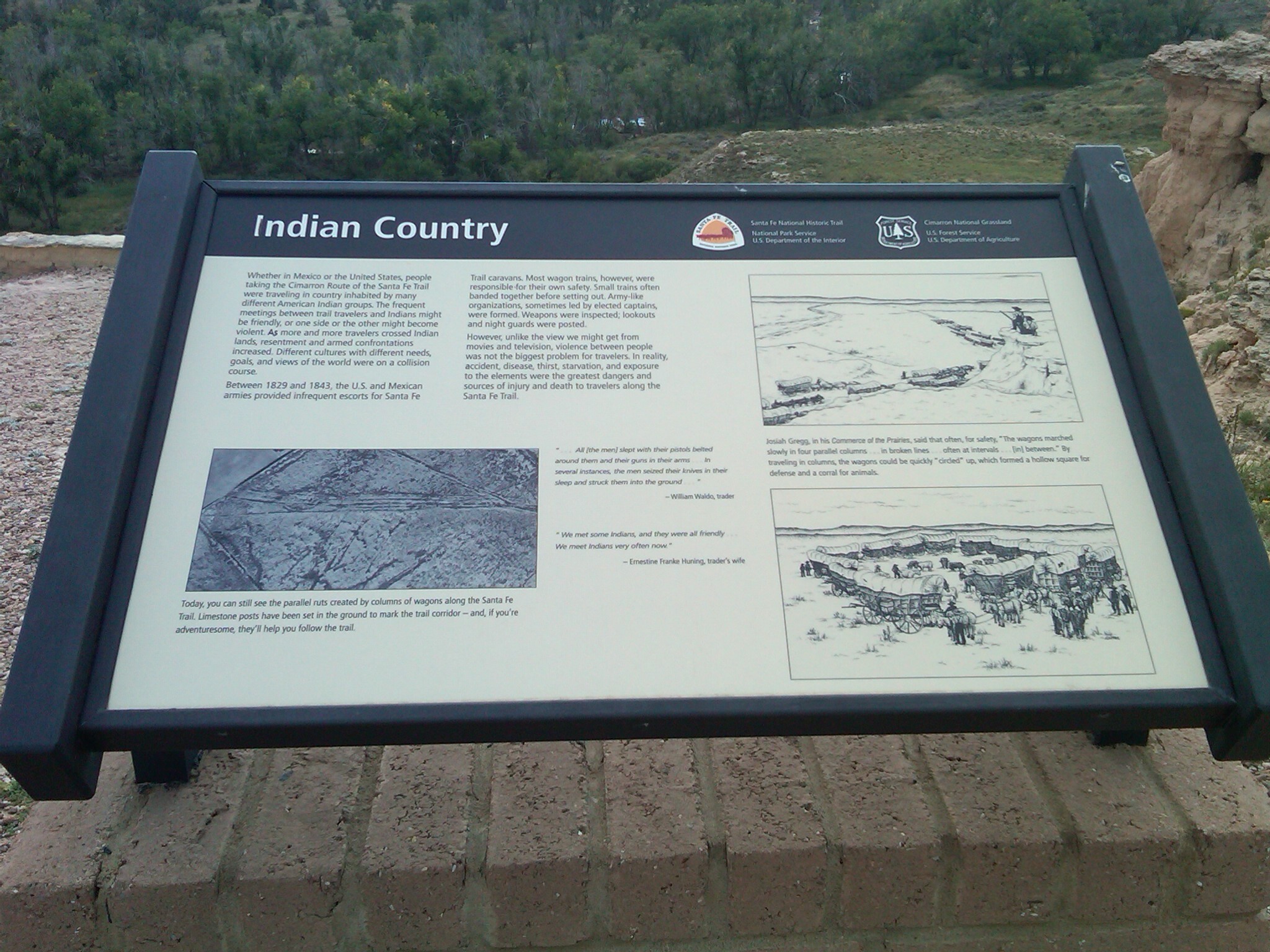 A wayside titled "Indian Country" with some text and illustration on it in a grassy field.