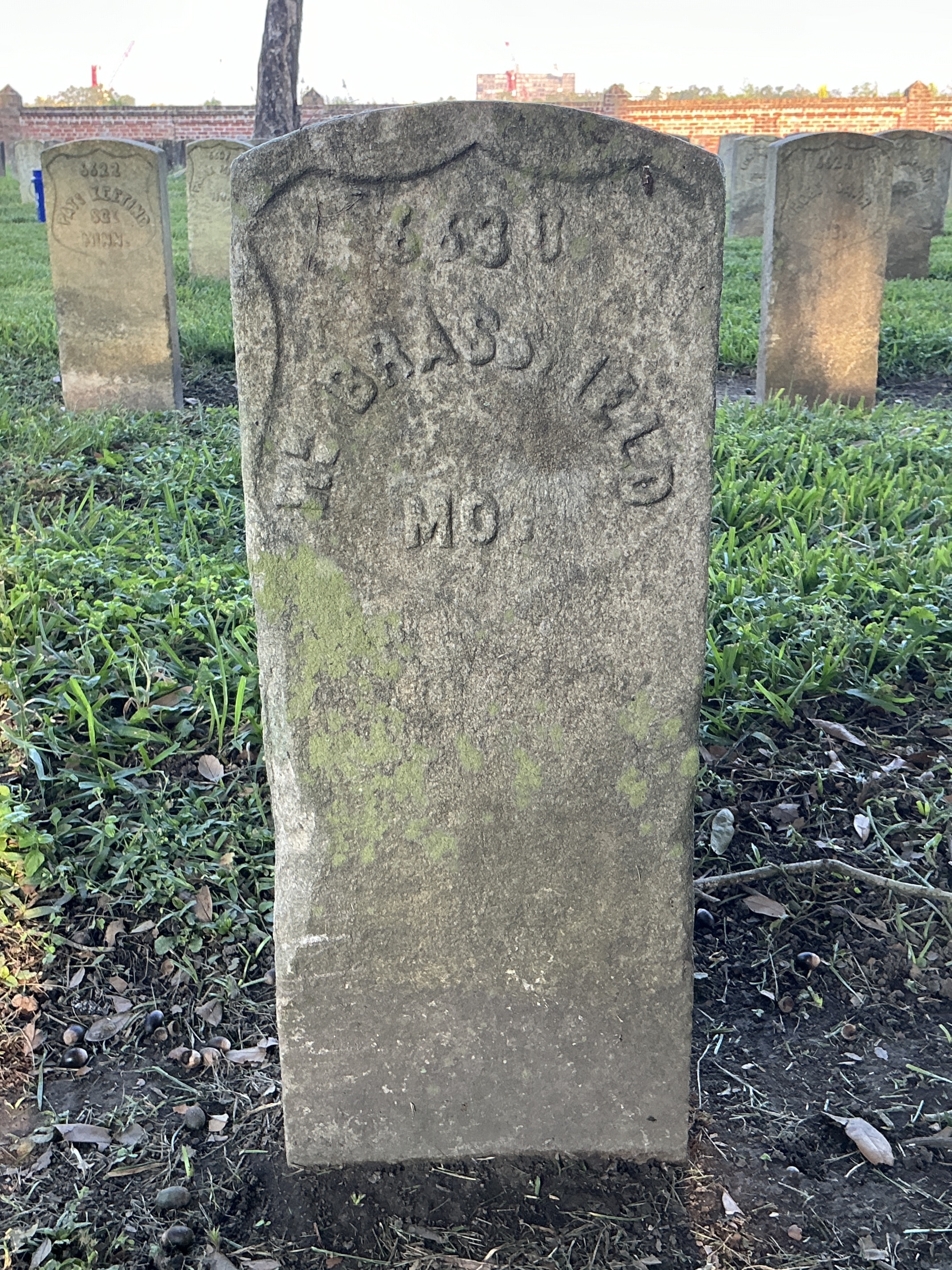 Front of historic upright marble headstone with recessed shield face.