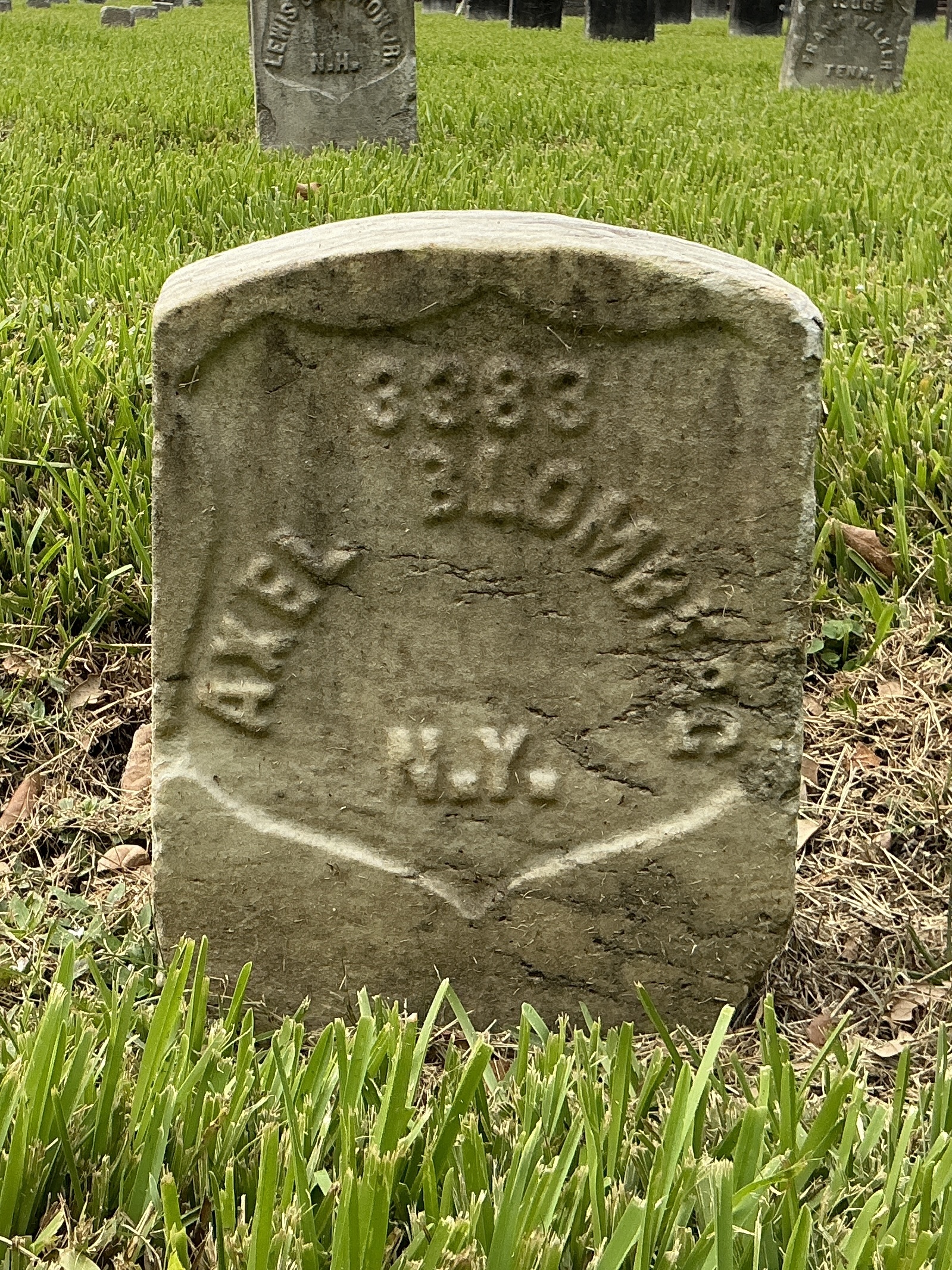 Front of historic upright marble headstone with recessed shield face.