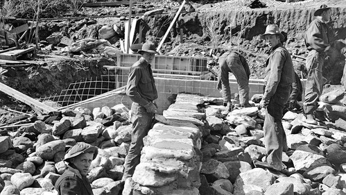 Civilian Conservation Corps (CCC) workers and park laborers engaged in diversion dam construction rock work.