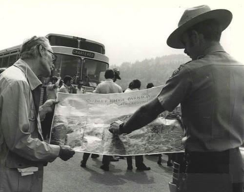 Park ranger gives a visitor directions using a park map