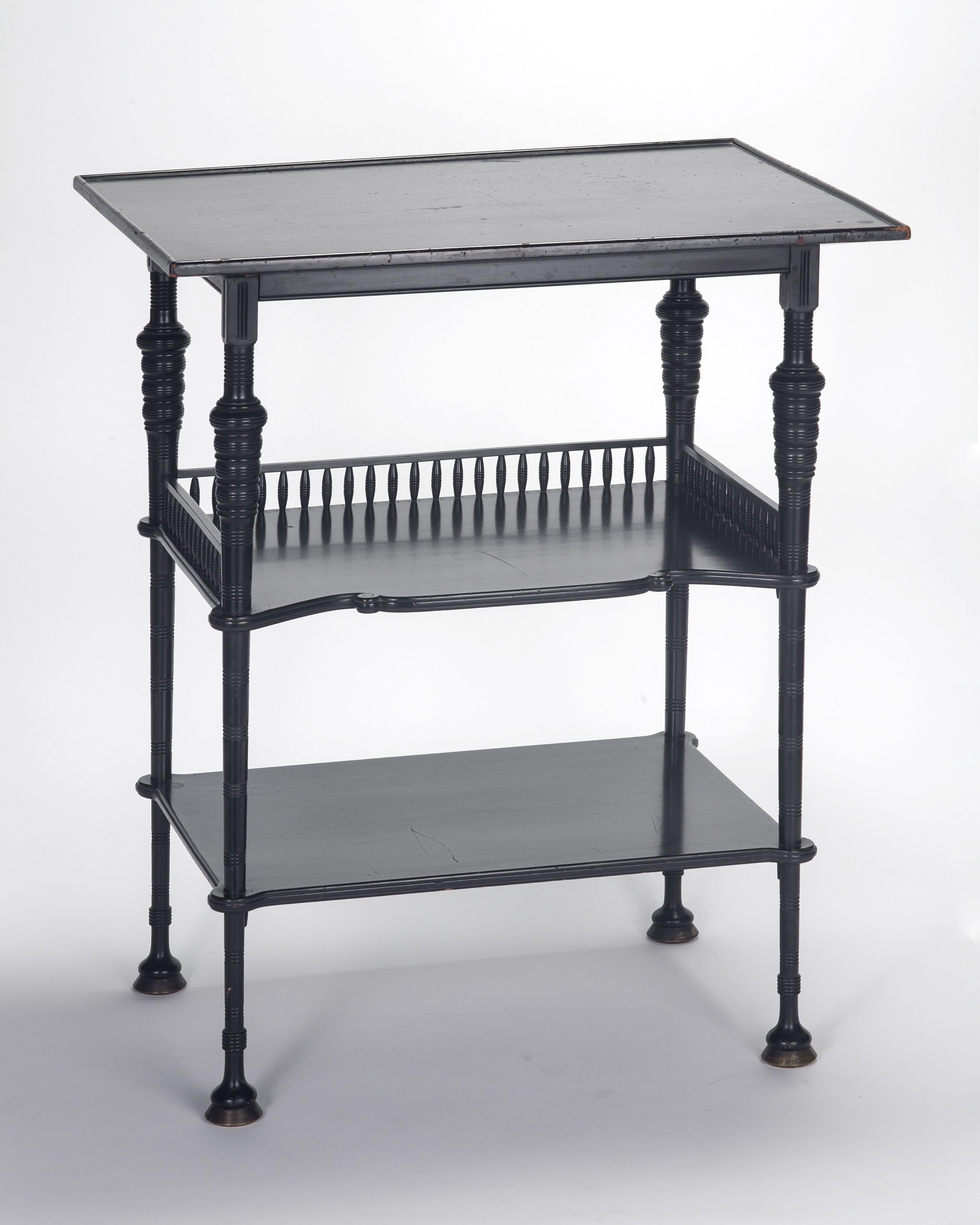 A table with delicate turned legs and two shelves below the top.