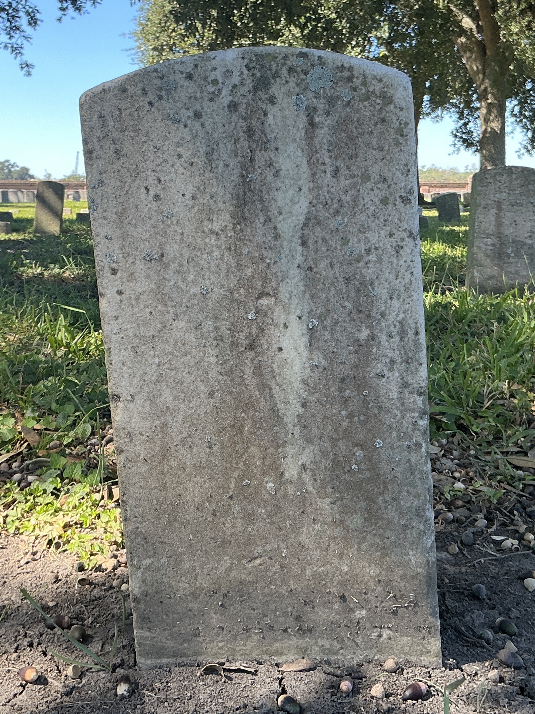 Back of historic upright marble headstone with recessed shield with recessed lettering face.