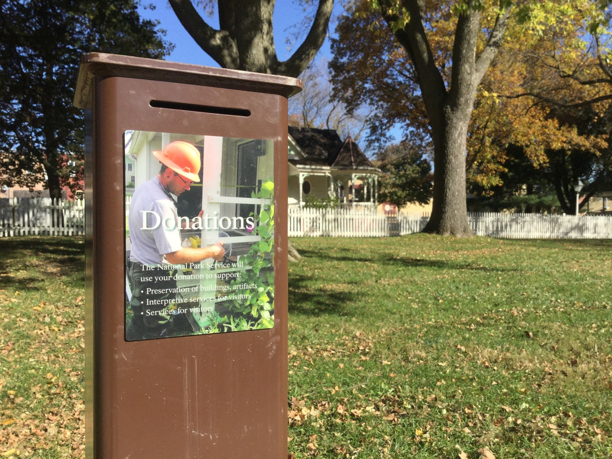 An illustrated sign identifies a metal box as a donation box.