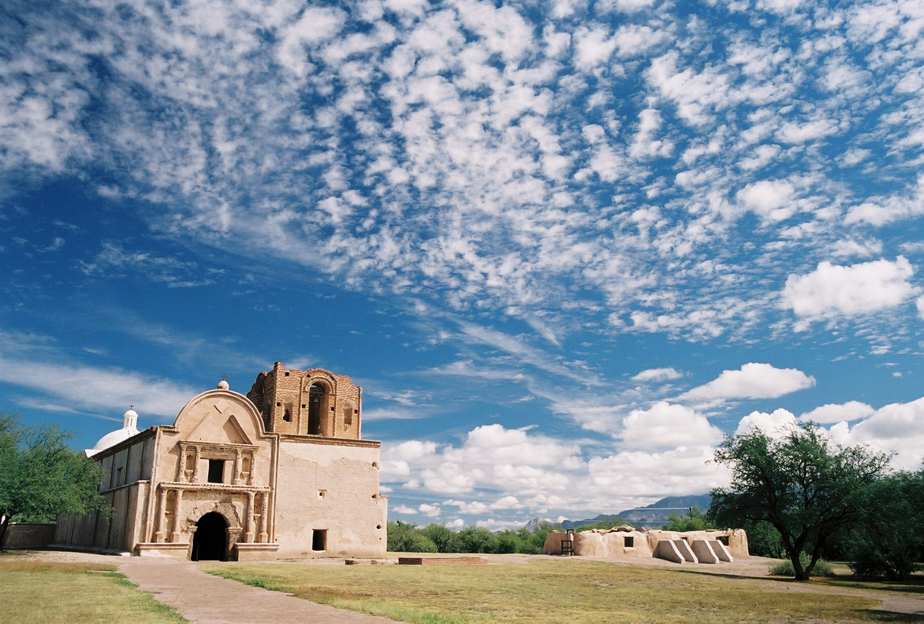 mission church and grounds with interesting cloud pattern in very blue sky