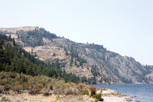 Color photograph of cliffs rising above a lakeshore