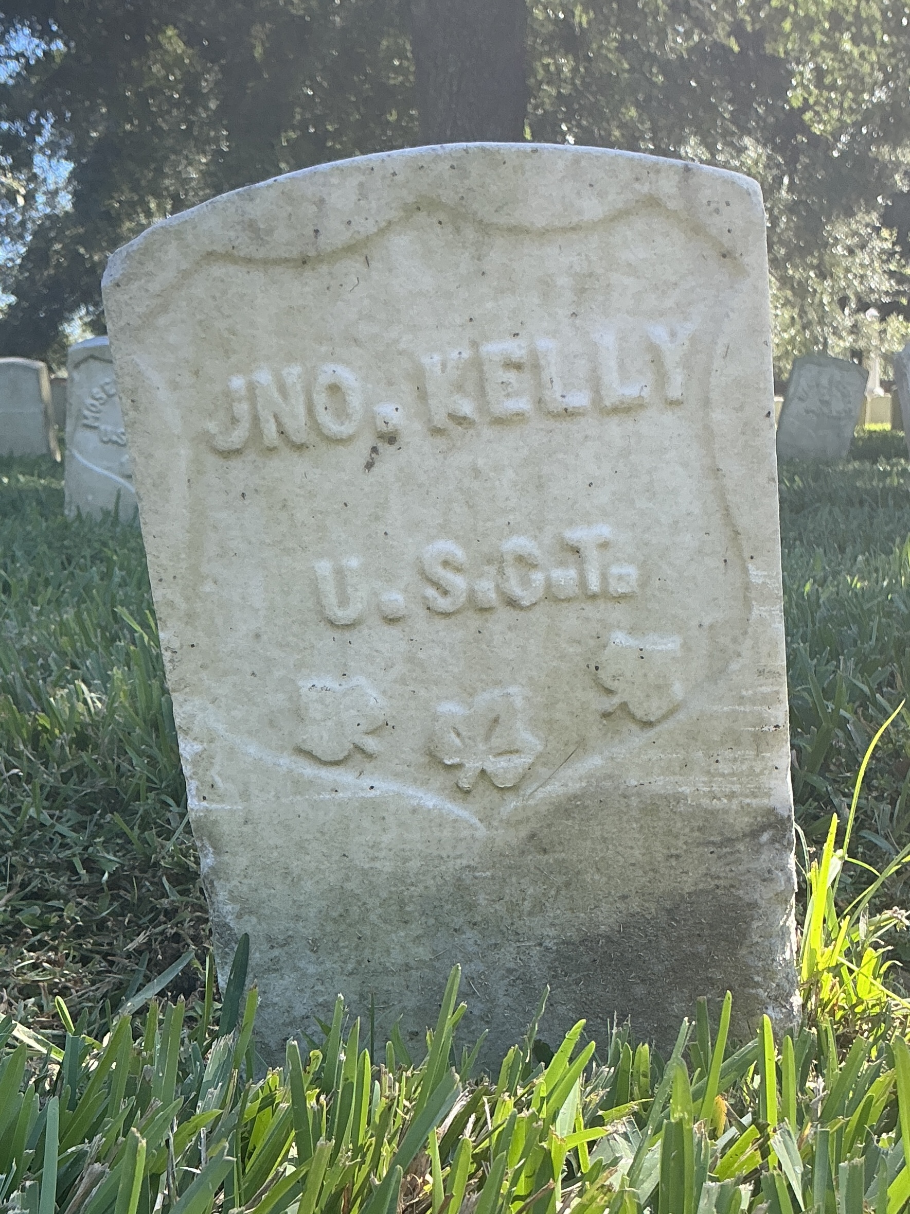 Back of historic upright marble headstone with recessed shield face.