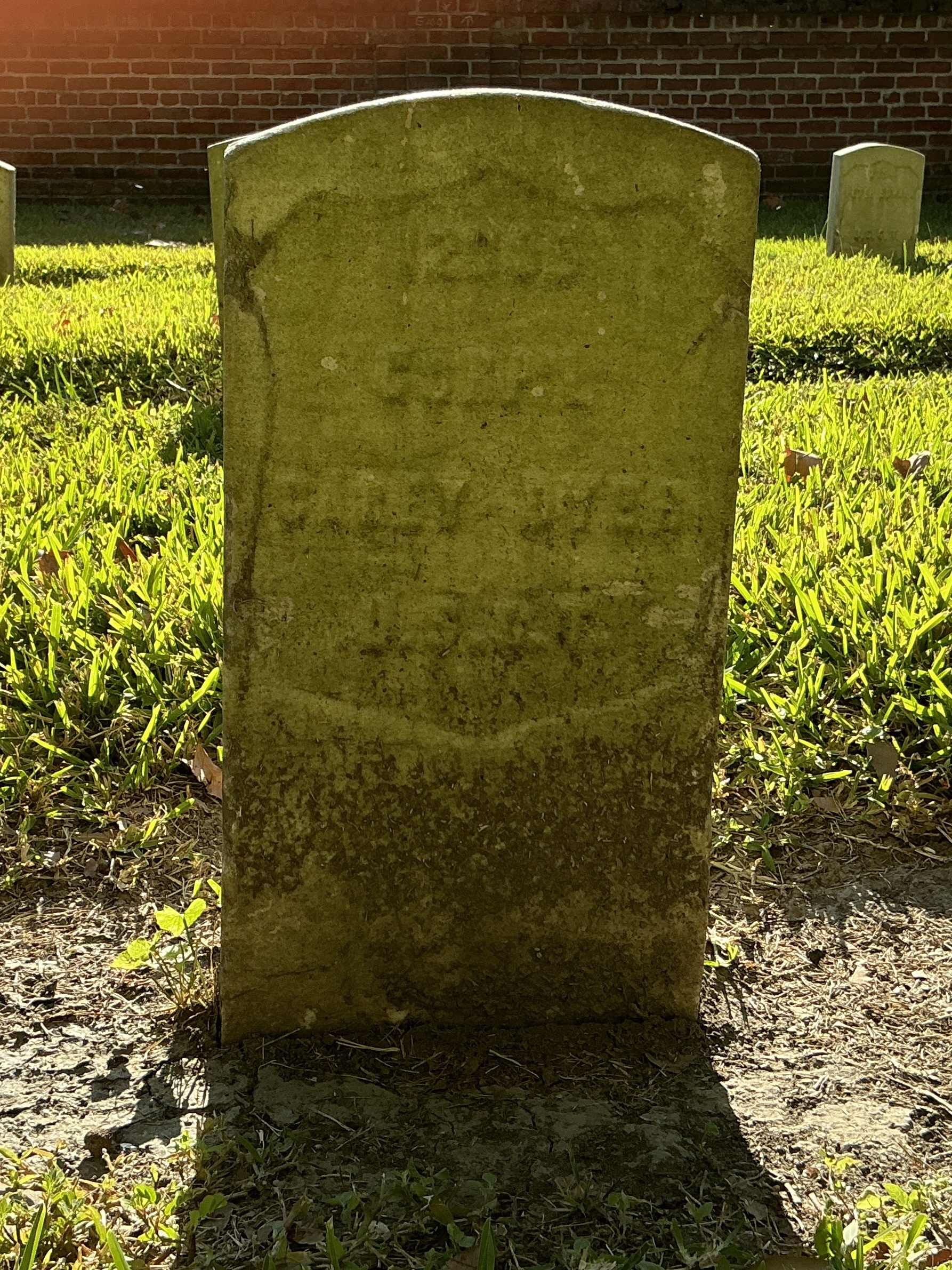 Front of historic upright marble headstone with recessed shield face.