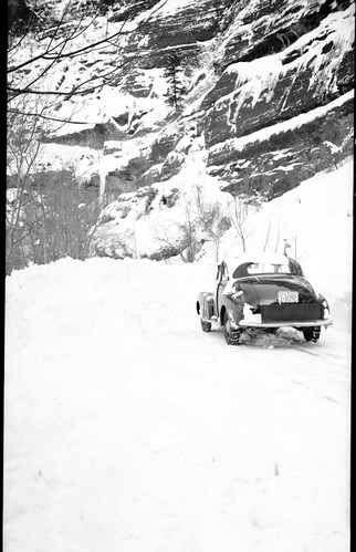 Snow slide and car and damage to road.