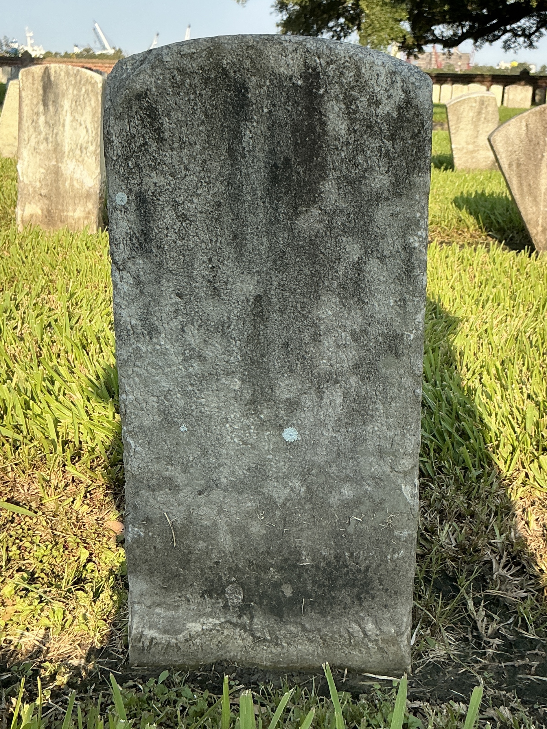 Back of historic upright marble headstone with recessed shield face.
