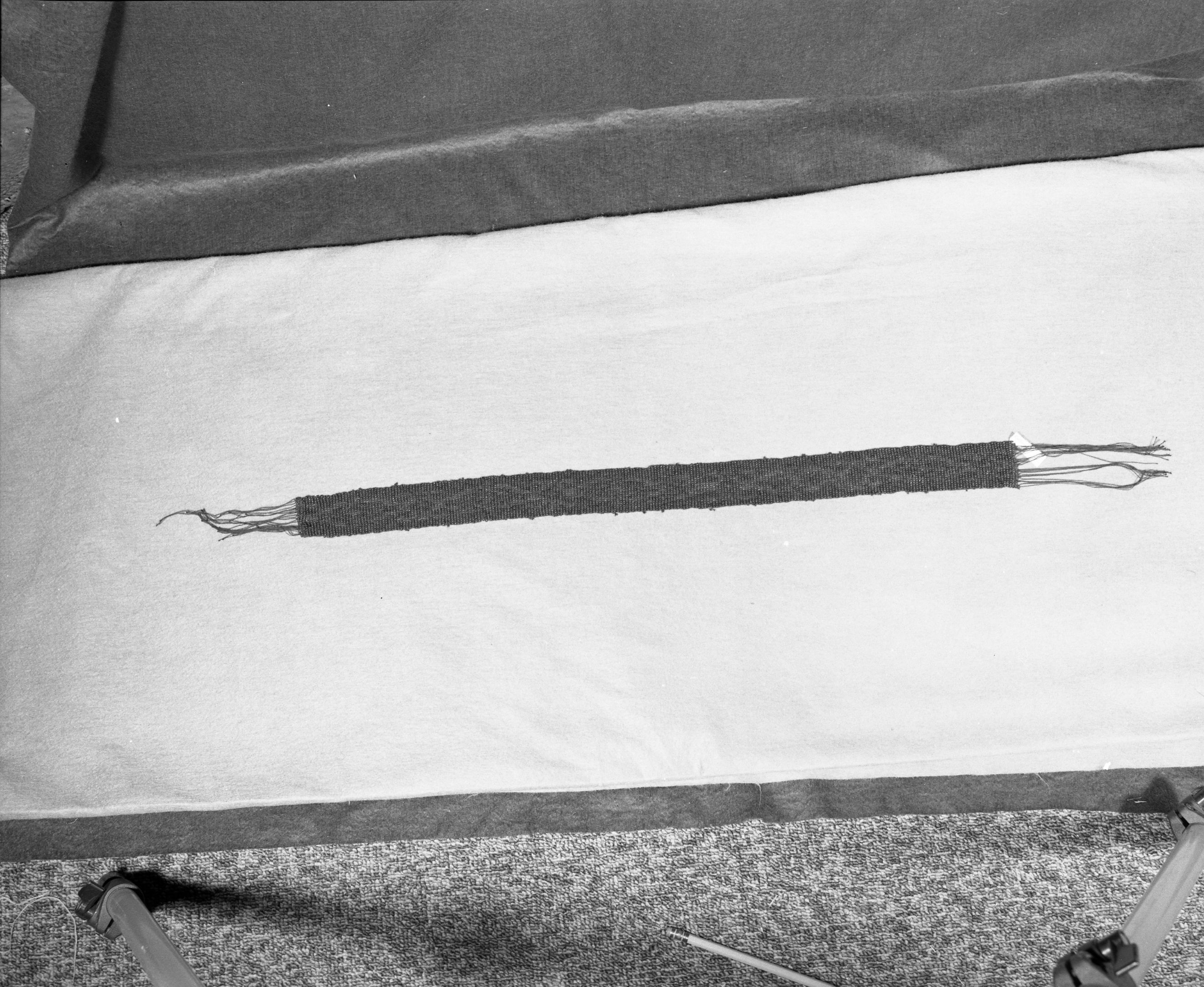 Marie Rozier Collection, Catalog No. 139. Object: Miwok beaded band. Dimensions: 24 x 1 1/2". Materials: Transparent red and blue beads; black thread. Technology: Loomless beadwork, double weft. Collection History: Made by Mrs. Louise Fuentes, 1950s. Photographed by Michael Dixon in December 1982. Catalogued by Craig Bates and Barbara Beroza. Yosemite Collections, National Park Service.