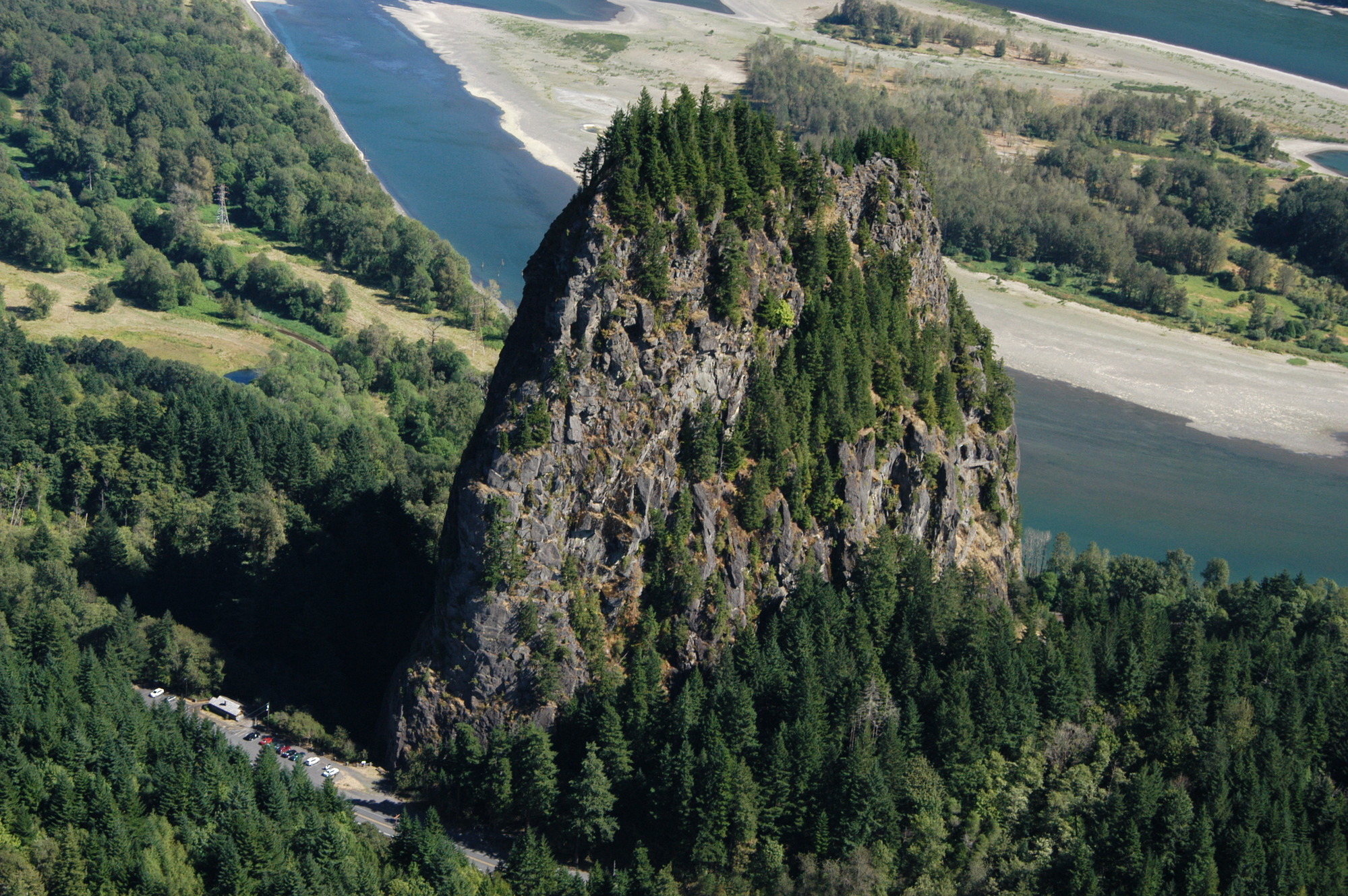 Photograph of Beacon Rock towering over the landscape with the Columbia River in the background. 

