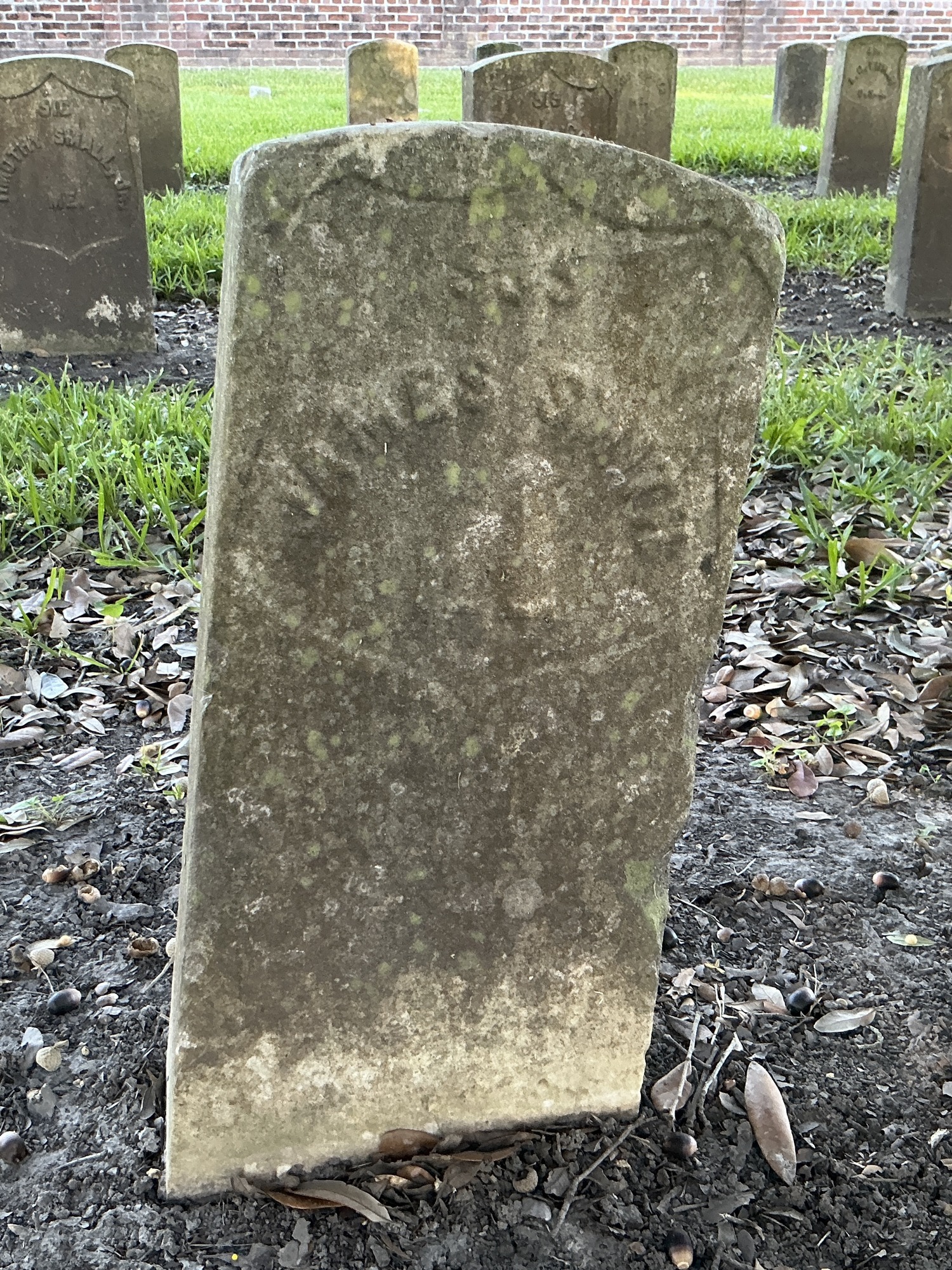 Front of historic upright marble headstone with recessed shield face.