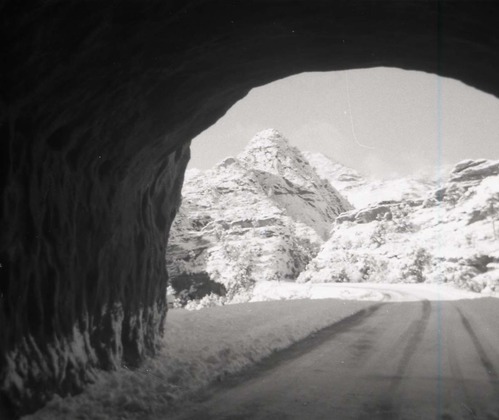 BW photo of snowy road through small tunnel on east side of park.