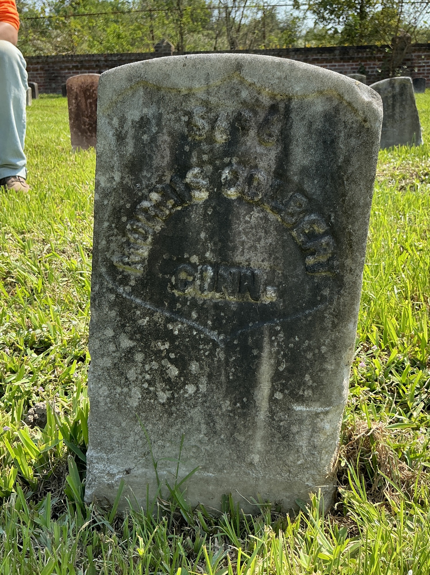 Front of historic upright marble headstone with recessed shield face.