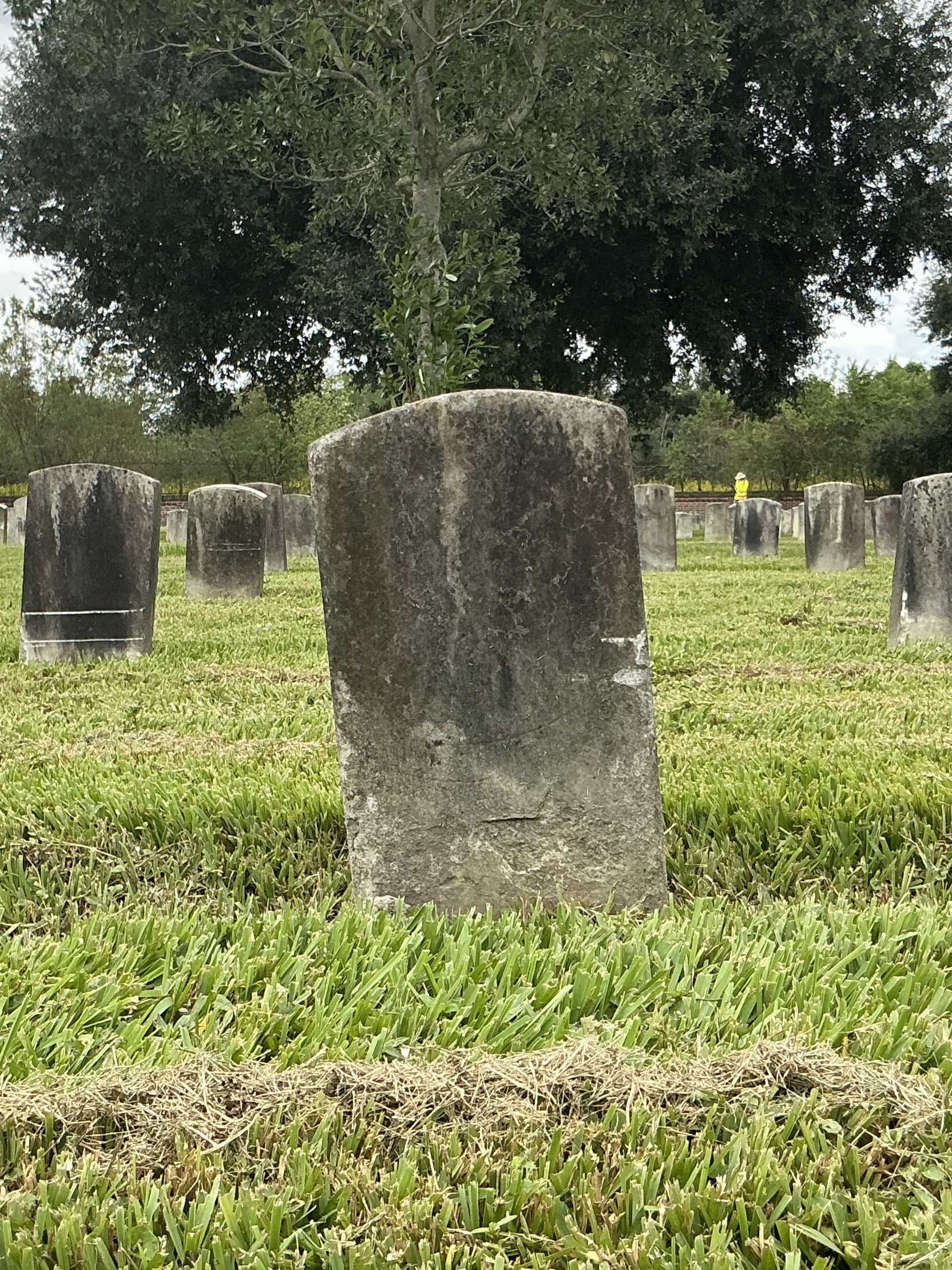 Back of historic upright marble headstone with recessed shield face.