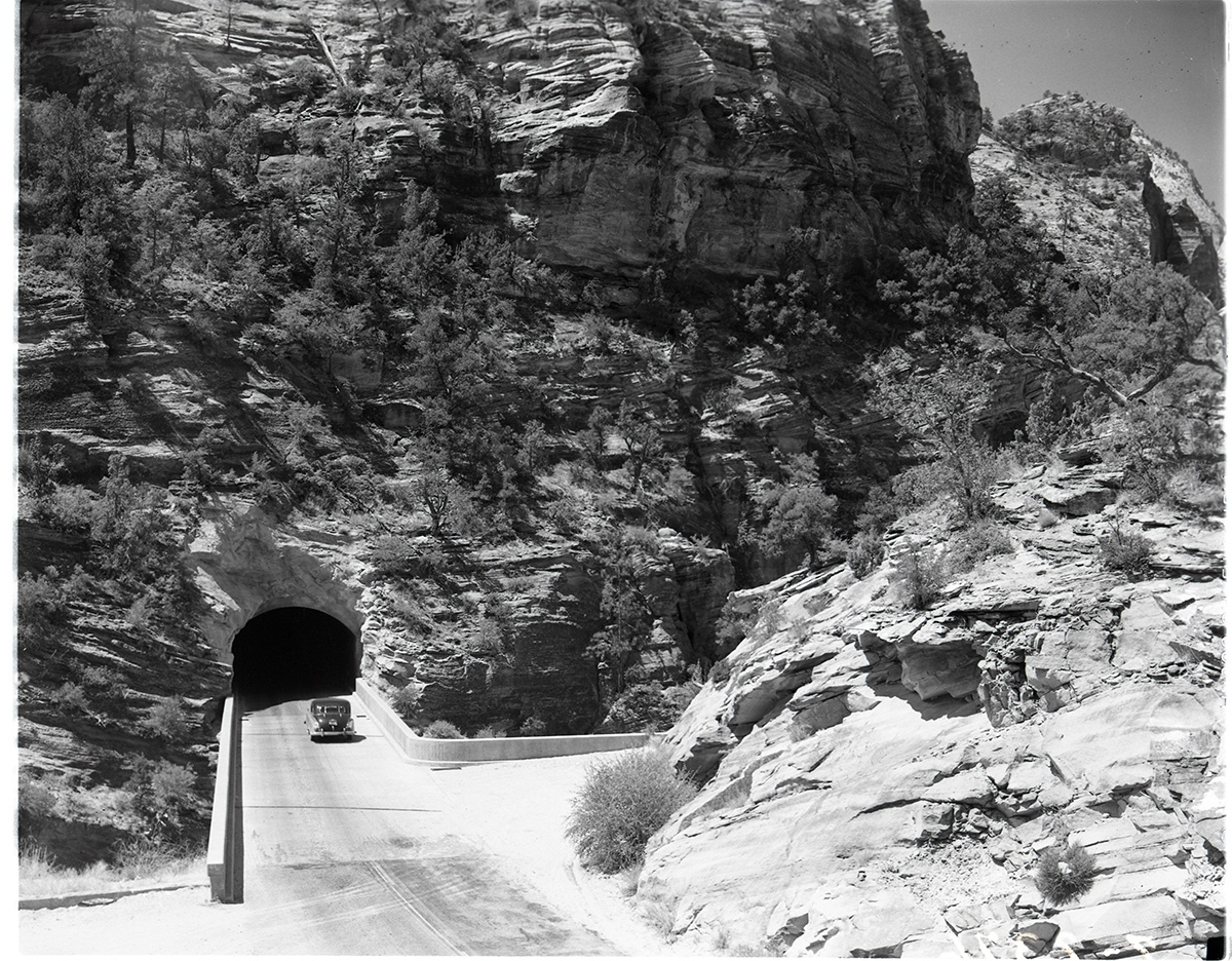 East end of Zion-Mt. Carmel tunnel from Pine Creek crossing. Two vehicles near tunnel.