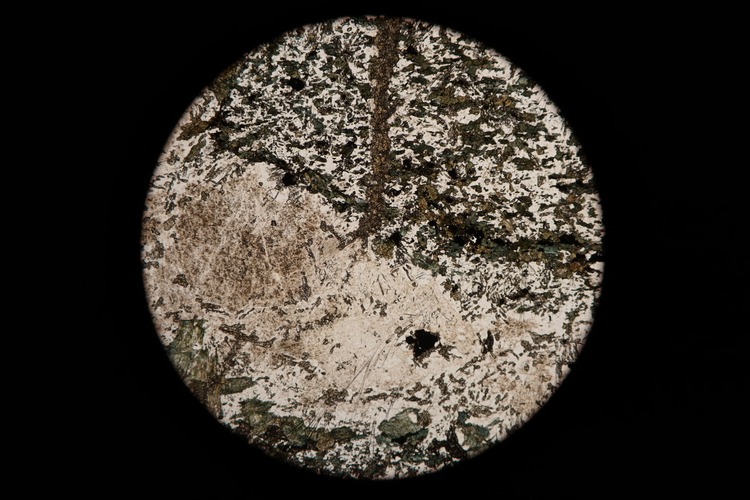 Circular microscopic image of rock structure.
