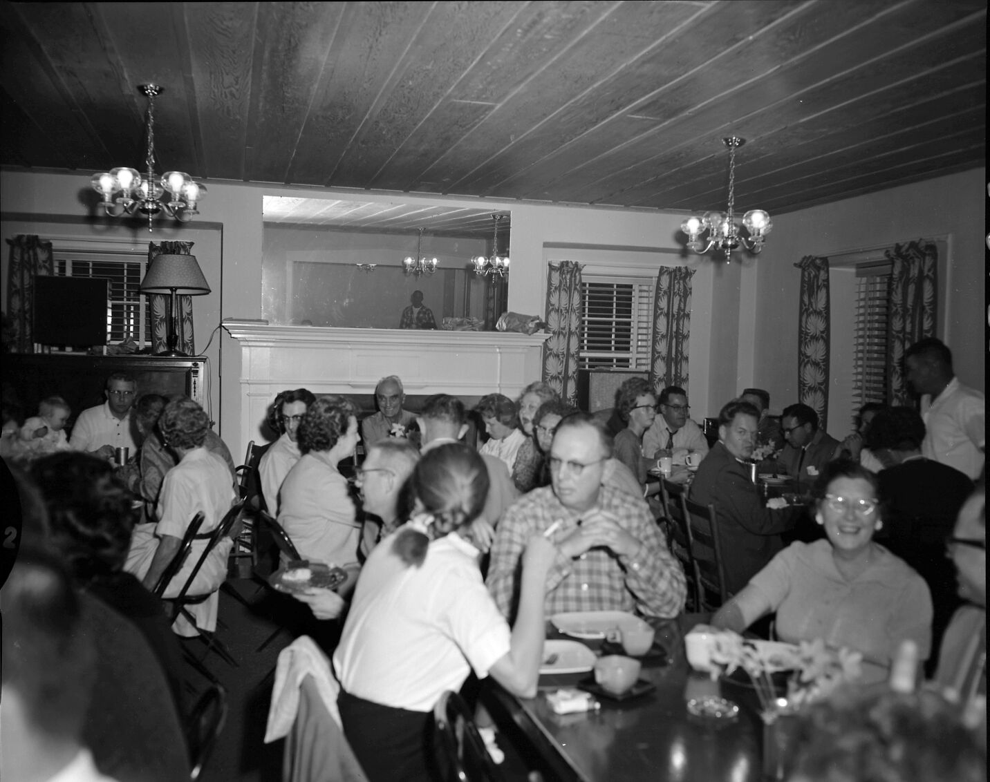 Men and women eating dinner at Harry Brockmeier's retirement party in the ranger dormitory.