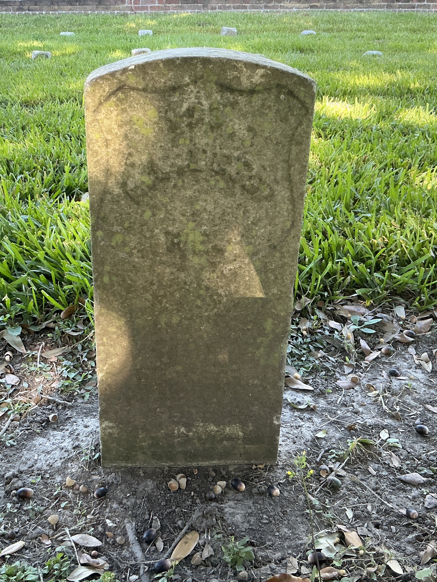 Front of historic upright marble headstone with recessed shield face.