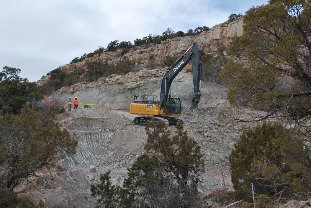 Excavator picking up shovel full of dirt on Rim Rock Drive on February 5, 2018.