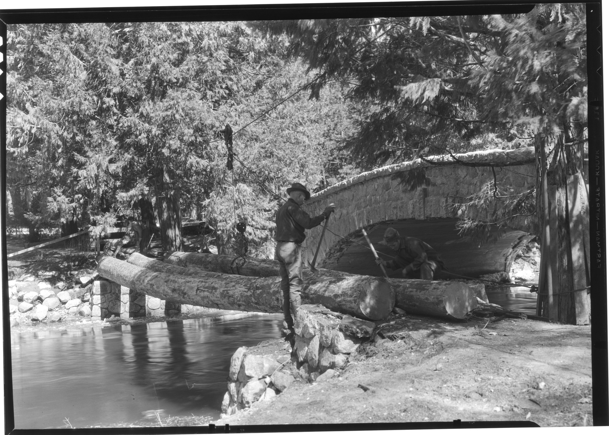 Laying stringers for footbridge across Yosemite Creek near the Lodge.