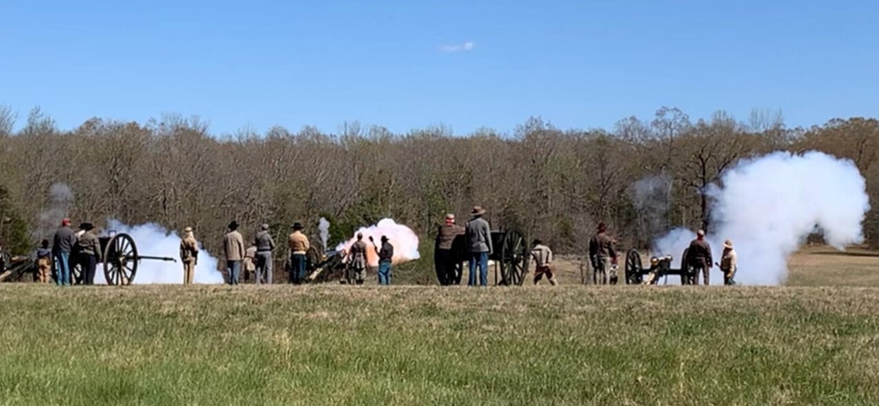 Smoke billows from several cannon