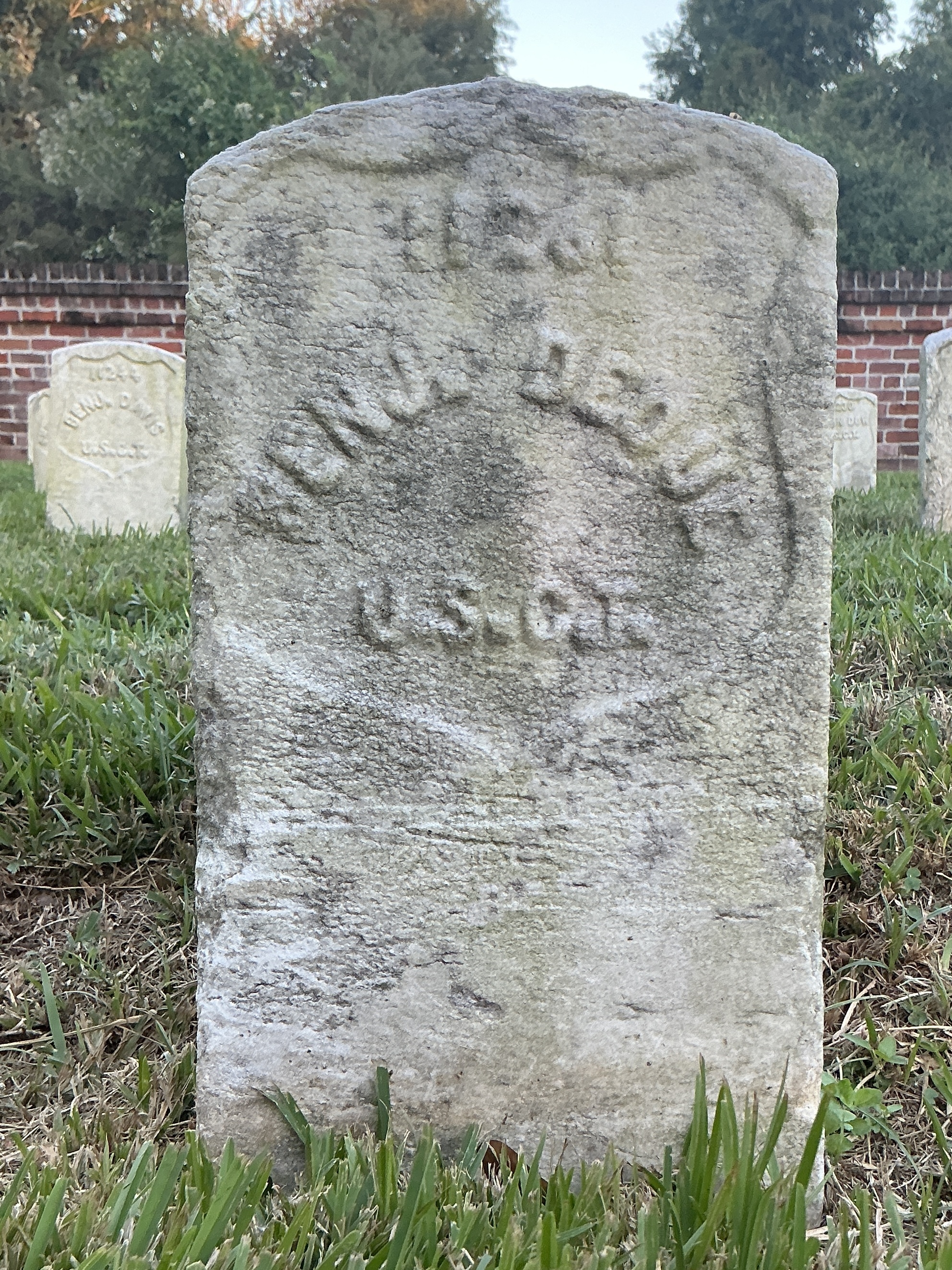 Front of historic upright marble headstone with recessed shield face.