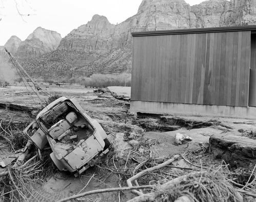 The December 6, 1966 flood damage - in Watchman campground near amphitheater with damaged truck, debris, and erosion after the water receded.