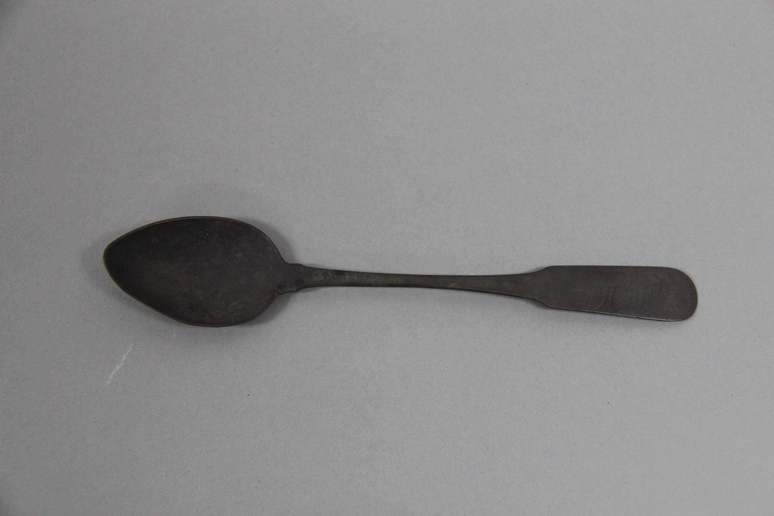A spoon, discolored with age