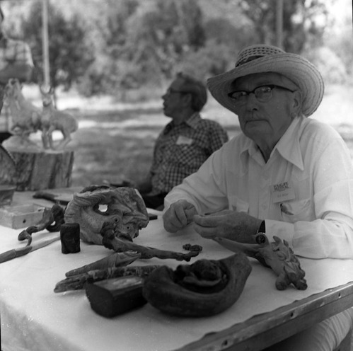 Bill Miller carving a peach pit creature at the first annual Folklife Festival, Zion National Park Nature Center, September 1977.