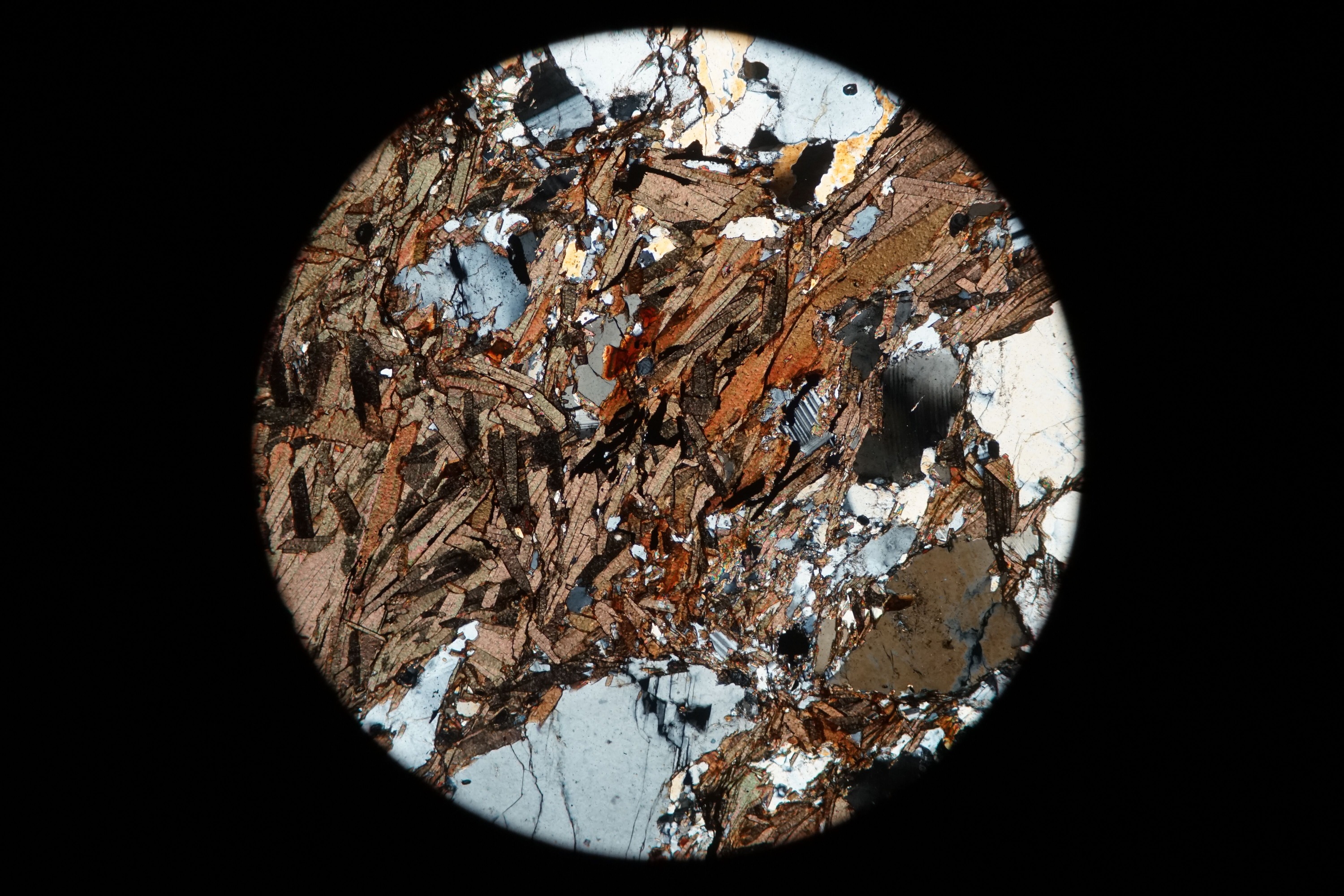 Circular microscopic image of rock structure.