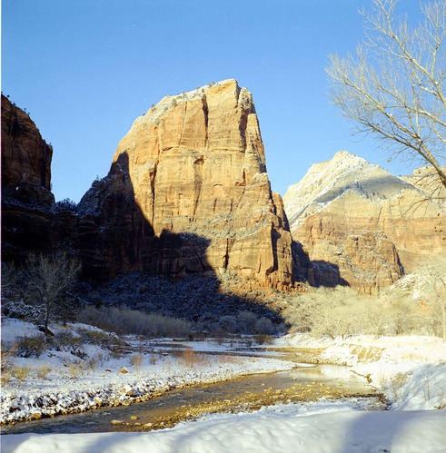 View of Angels Landing from canyon floor, snow along banks of the Virgin River.