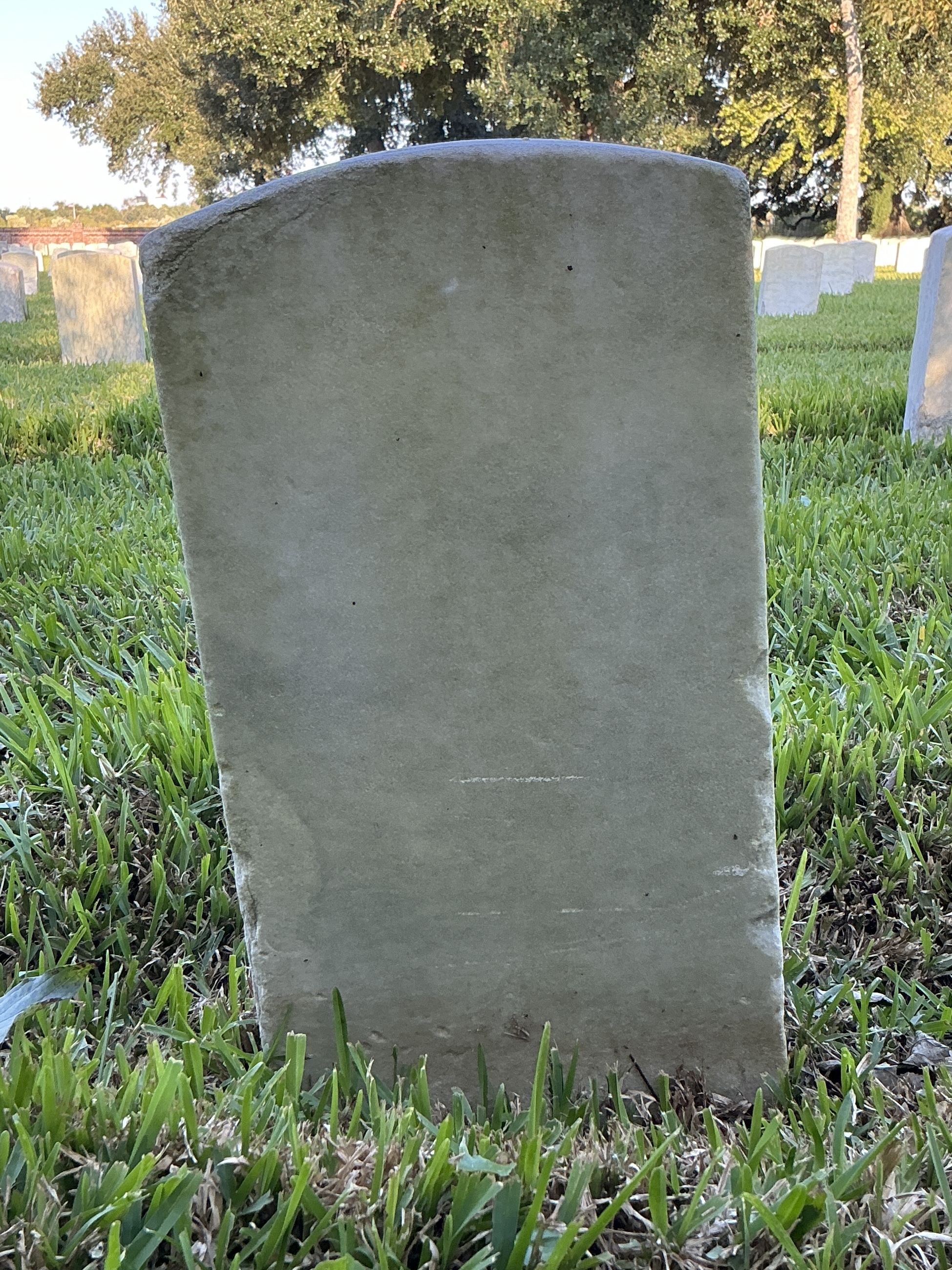 Back of historic upright marble headstone with recessed shield face.