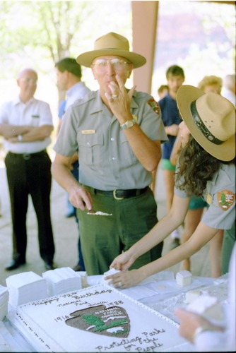 Color Photos of the parks 72nd anniversary celebrations- cake cutting, barbecue, speakers. Superintendent Harold Grafe serving cake with Blanca Stransky.