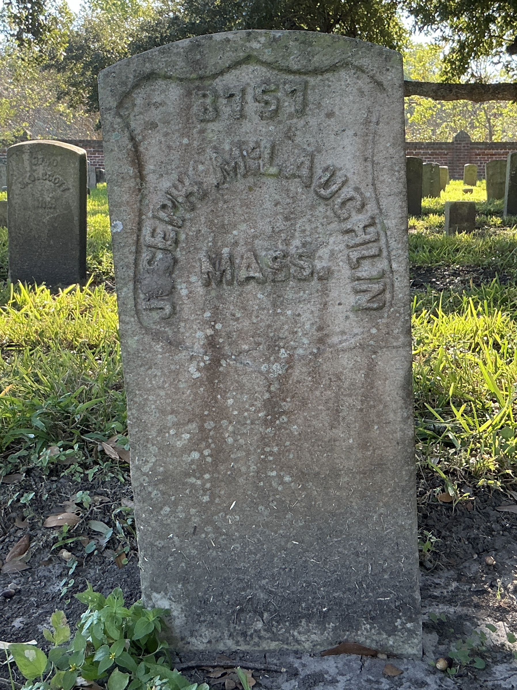 Front of historic upright marble headstone with recessed shield face.