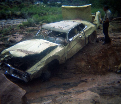 Color photos of park personnel removing a car from the flood waters of the 1975 flood.