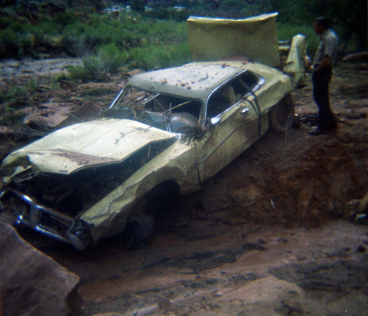 Color photos of park personnel removing a car from the flood waters of the 1975 flood.