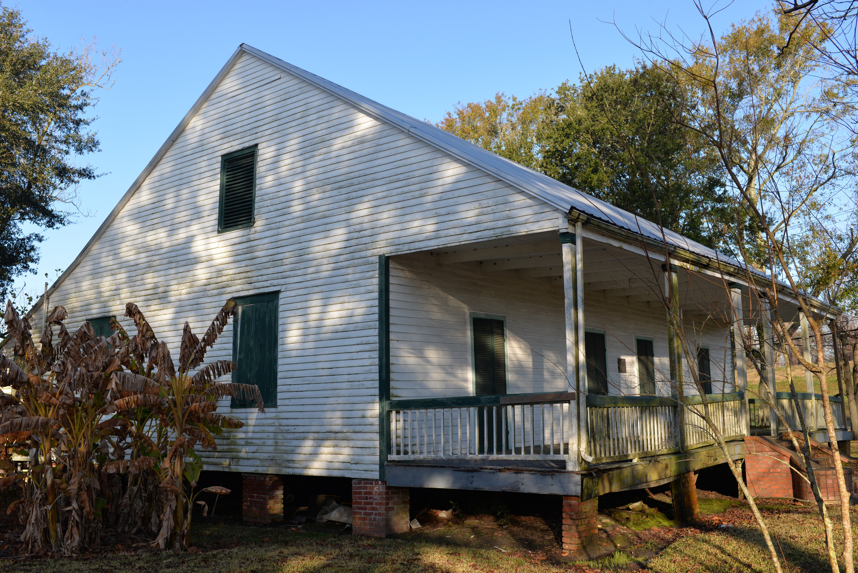 White sided structure with green accents.