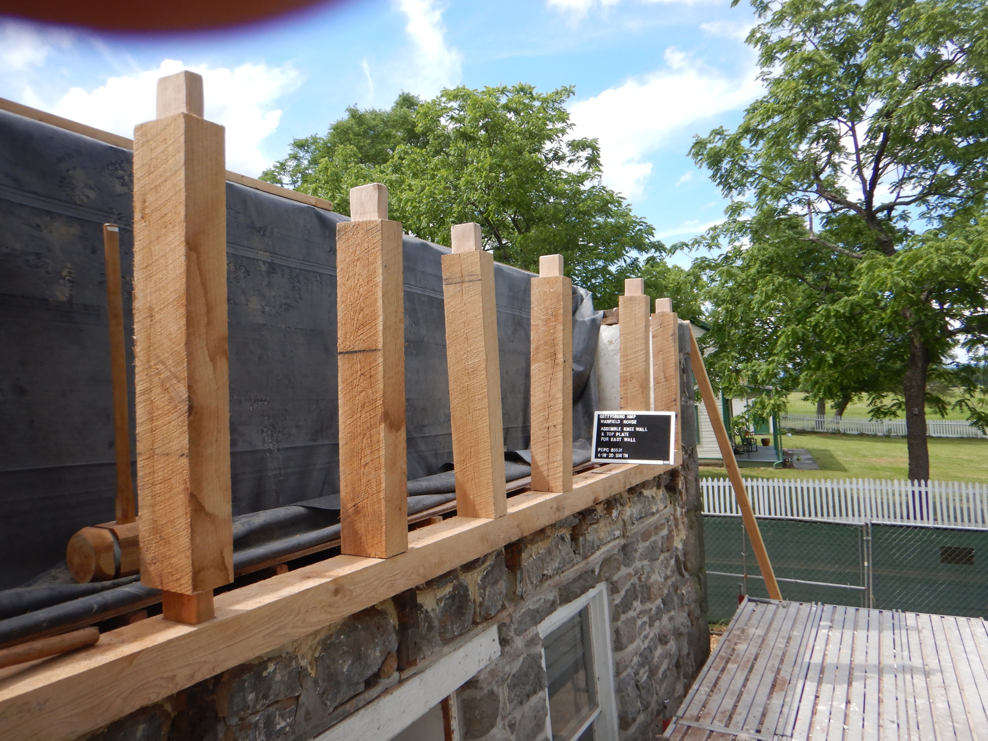 6 timber pieces are assembled to create a "knee wall". They are sitting on top of the masonry structure that was previously concealed by the non-historic porch roof. 