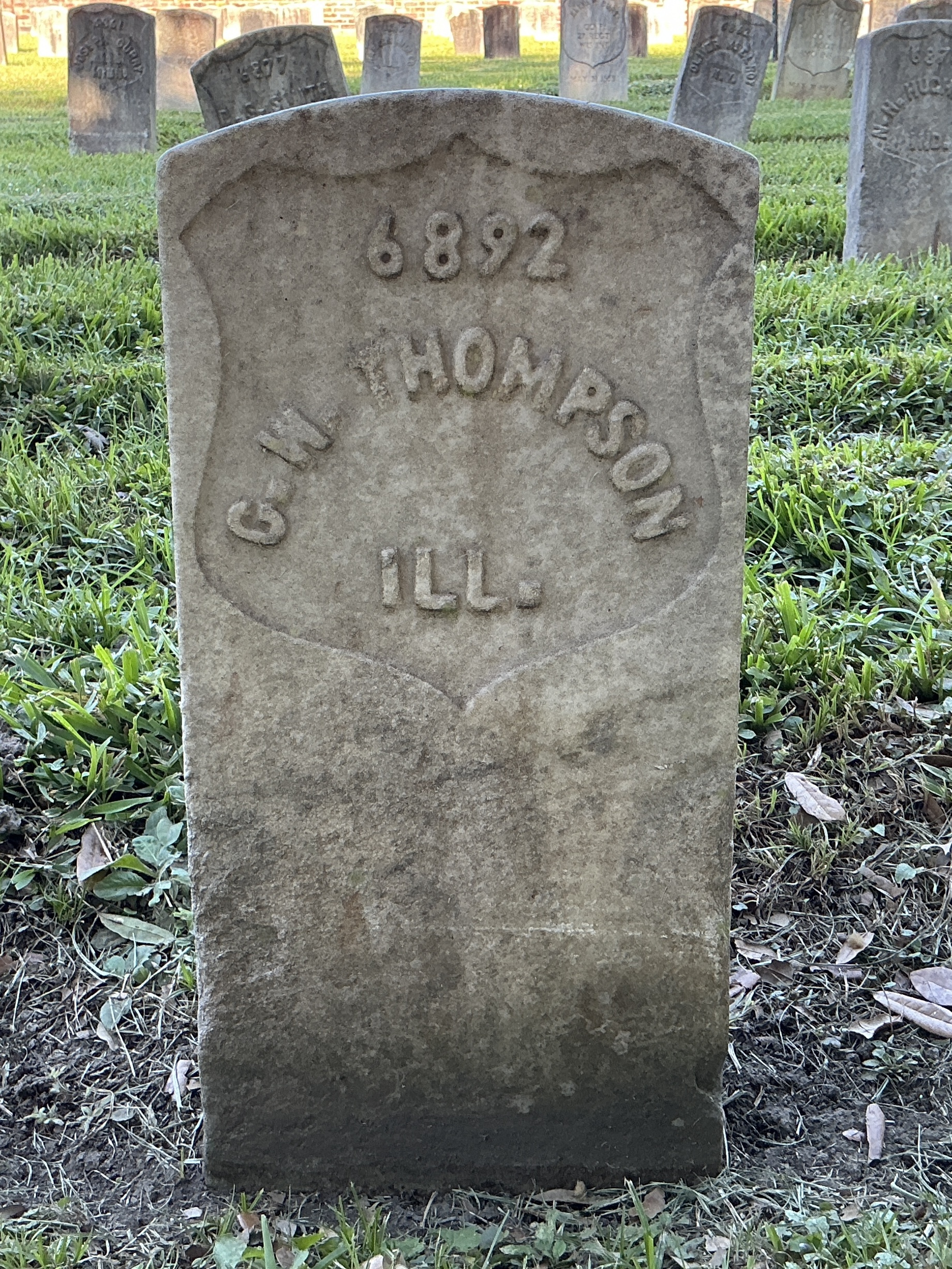 Front of historic upright marble headstone with recessed shield face.